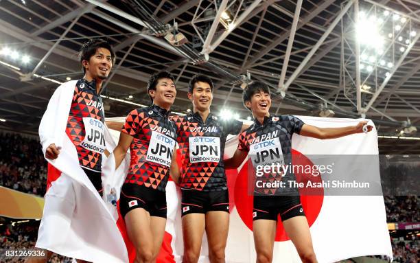 Shuhei Tada, Shota Iizuka, Yoshihide Kiryu and Kenji Fujimitsu of Japan celebrate winning bronze in the Men's 4x100 Relay final during day nine of...