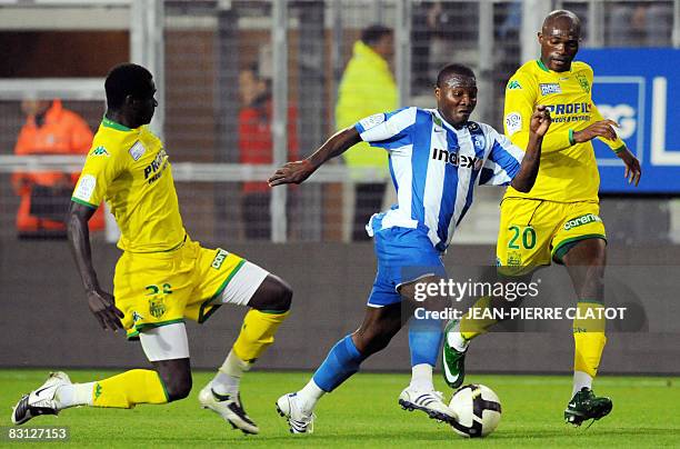 Grenoble's Franck Dja Dje Dje vies with Nantes' Aymard Bekamenga and Guirane N'Daw during the French L1 football match Grenoble vs Nantes, on October...