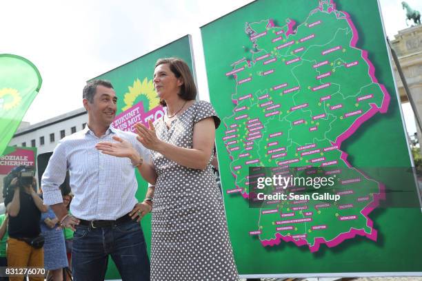 Cem Oezdemir and Katrin Goering-Eckardt, lead candidates of the German Greens Party , stand in front of a map of Germany showing their upcoming...