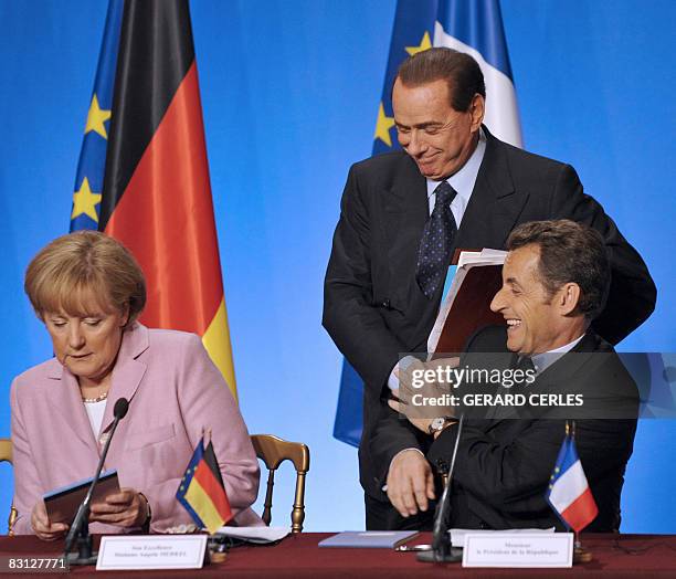 French President Nicolas Sarkozy , flanked by Italian Prime Minister Silvio Berlusconi and German chancellor Angela Merkel, participates in a final...