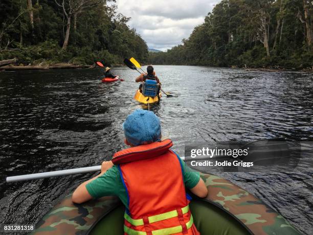 family kayaking and rafting down a river in the wilderness - kayaking australia stock pictures, royalty-free photos & images