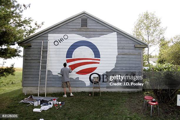 Volunteer Brian Heath paints an Obama campaign logo on the side of Gary Lahman's garage, October 4 in support of US Democratic presidential candidate...