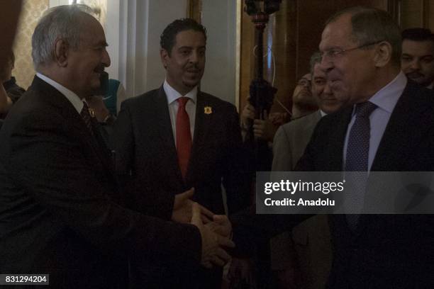 Russian Foreign Minister Sergei Lavrov and Libyan National Army Commander Khalifa Haftar shake hands before their meeting in Moscow, Russia on August...