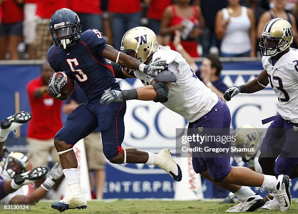 Nic Grigsby of the Arizona Wildcats tries to escape the tackle of Daniel Te'o-Nesheim of the Washington Huskies during a first quarter run on October...