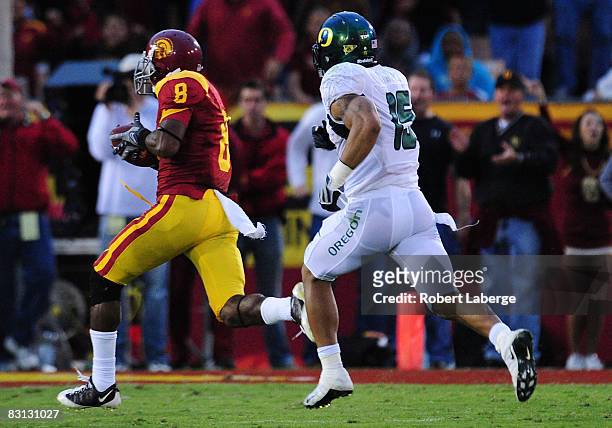 Ronald Johnson of the USC Trojans runs in for a touchdown after making a catch as Patrick Chung of the Oregon Ducks tries to catch him during the...