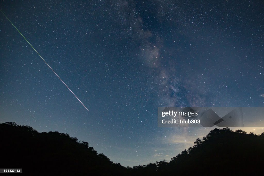 Dispara a un meteorito por el cielo de cielo de noche dejando un rastro de luz a través de la vía Láctea