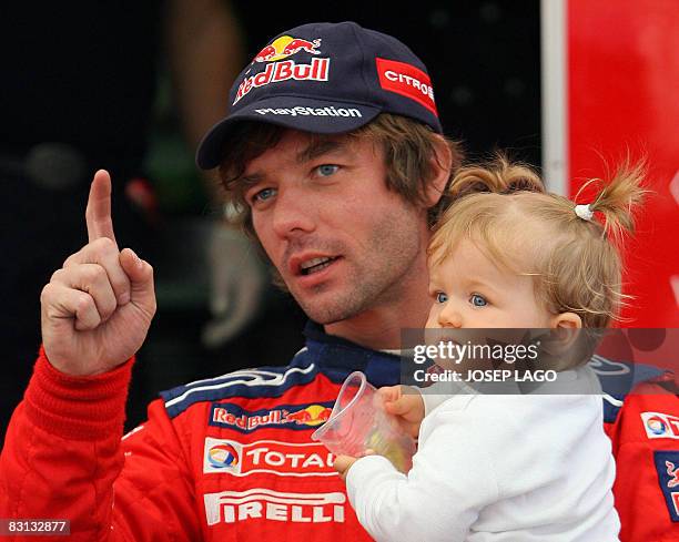 France's Sebastien Loeb walks with his daughter prior to the second stage of the 44 th Rally of Catalonia in El Molar near Tarragona on October 04,...