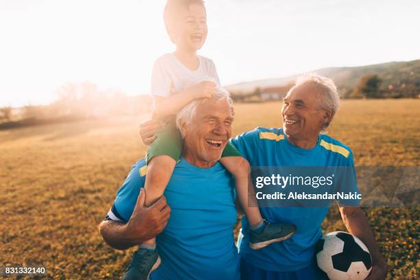 senior soccer players and their grandson - family football team stock pictures, royalty-free photos & images