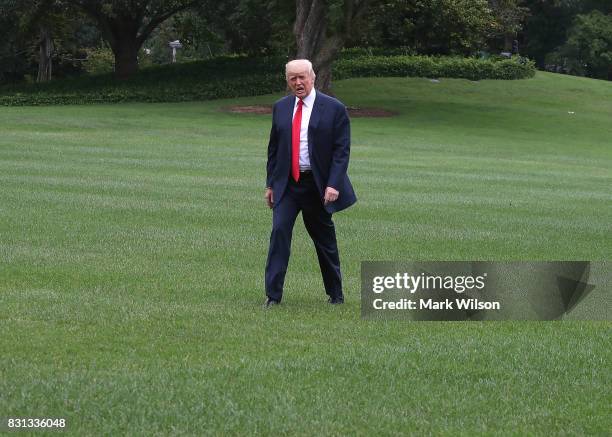 President Donald Trump walks toward the White House after stepping off of Marine One on the South Lawn on August 14, 2017 in Washington, DC. Later...