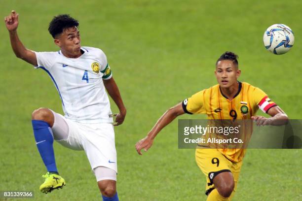 Muh Adib of Malaysia is checked by Faiq Jefri of Brunei during the preliminary round Group A football competition between Malaysia and Brunei at the...