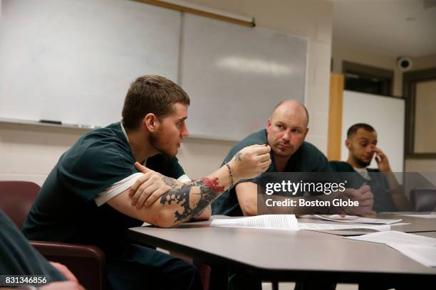 Inmate Devin Hurlburt, left, speaks about recovery as Robert Woods, center, looks on during a group session at the Franklin County House of...