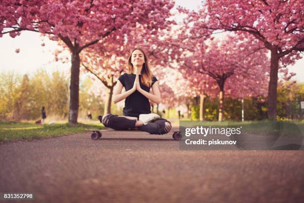 young woman with longboard in cherry blossom alley - piskunov imagens e fotografias de stock