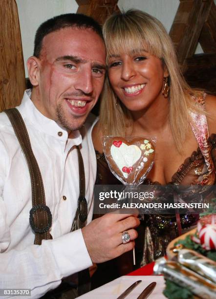 Bayern Munich's French midfielder Franck Ribery, dressed in traditional Bavarian clothes , offers his wife Wahiba Belhami a heart-shaped biscuit in a...