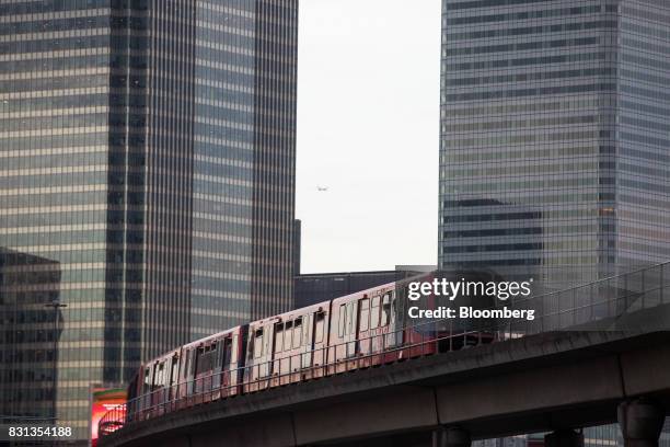 Docklands Light Railway passes office towers in the Canary Wharf financial, business and shopping district as it approaches East India station in...