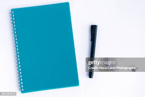 overhead view of pen and blue note pad on white background - cuaderno-de-ejercicios fotografías e imágenes de stock