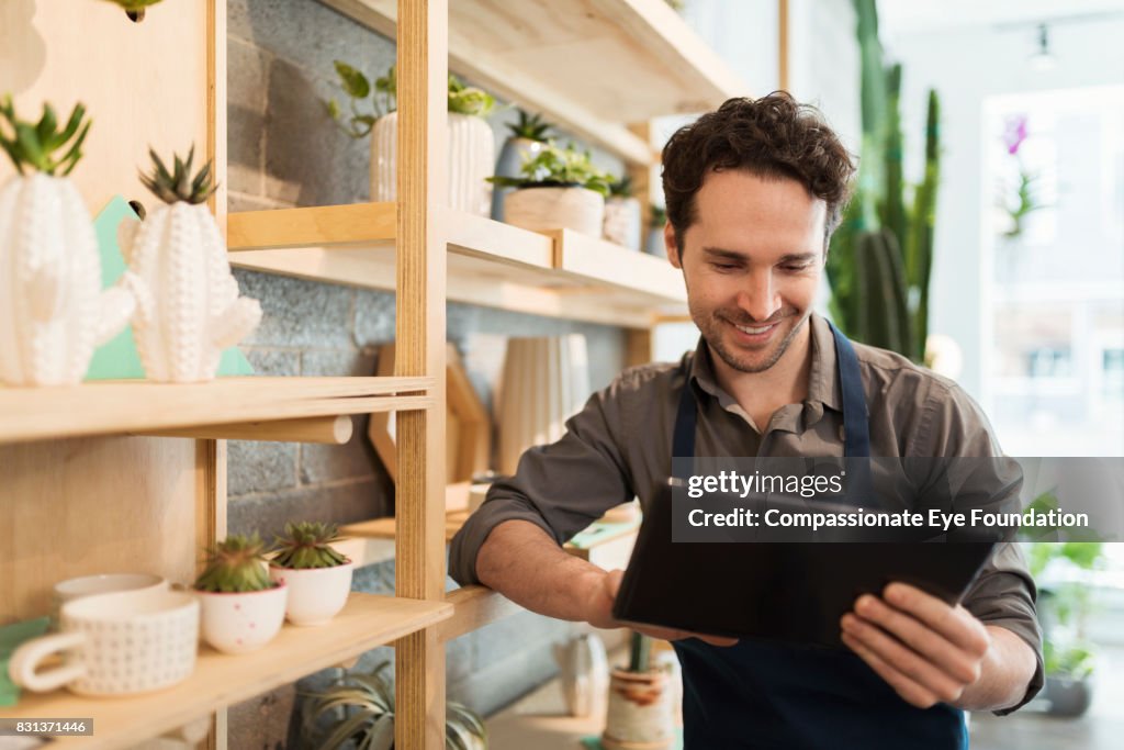 Florist using digital tablet in flower shop