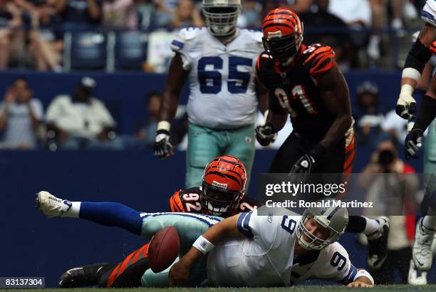 Quarterback Tony Romo of the Dallas Cowboys fumbles the ball against Frostee Rucker of the Cincinnati Bengals at Texas Stadium on October 5, 2008 in...