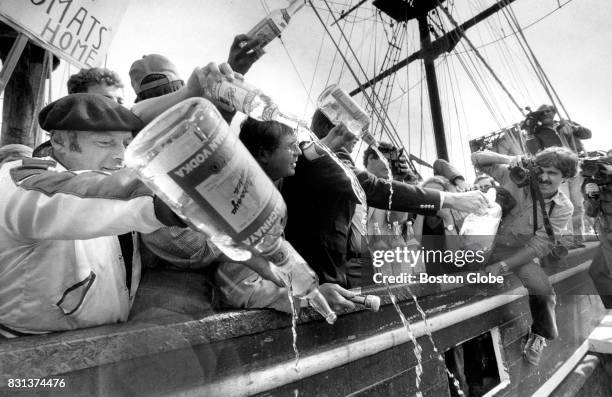 Protesters pour Russian Vodka into the Boston Harbor aboard the Boston Tea Party ship, Beaver, at its berth on Congress street in Boston, Sept. 14,...