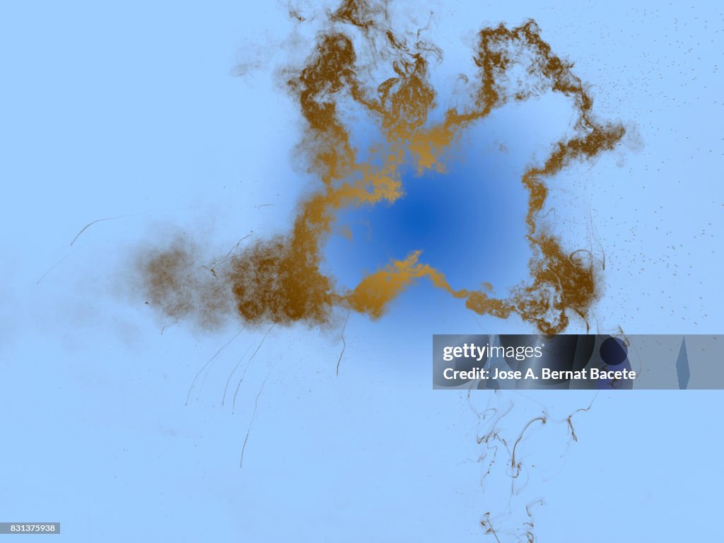 Forms and textures of an explosion of  powder in the form of a cloud of color brown on a blue background