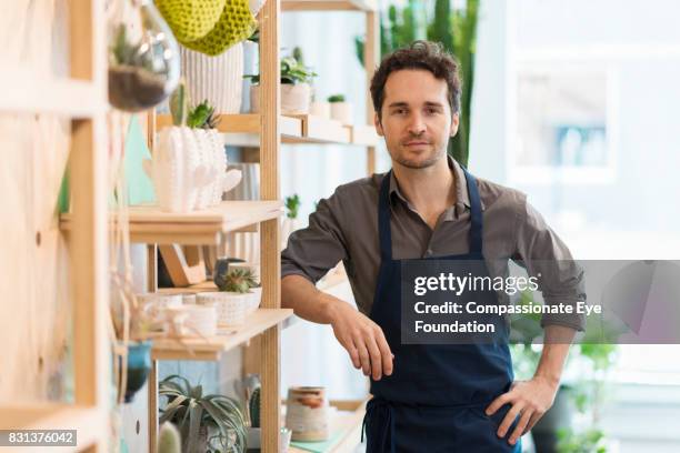 portrait of florist in flower shop - schürze stock-fotos und bilder