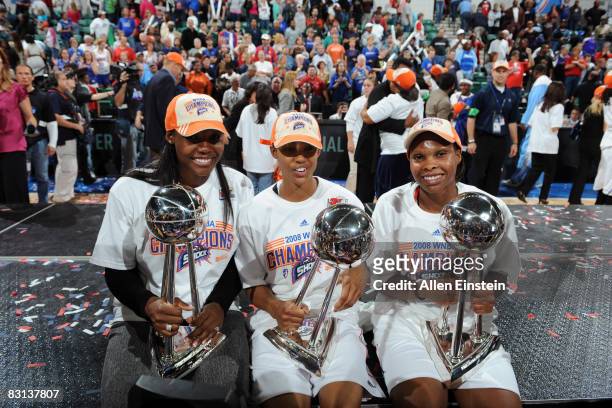 Cheryl Ford, Deanna Nolan, and Elaine Powell of the Detroit Shock holding their three trophies after they win against the San Antonio Silver Stars in...