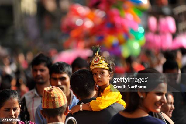 Father carrying his son impersonate as Lord Krishna during Krishna Janmashtami Festival celebrated at Patan, Nepal on Monday, August 14, 2017....