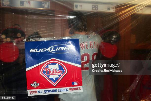 Jayson Werth of the Philadelphia Phillies takes a break from the locker room celebration to take a phone call after the Phillies defeated the...