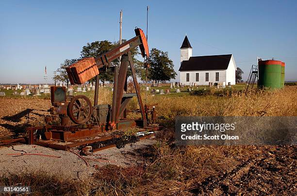 Rusting oil well sits at the edge of a corn field near the Asbury Methodist Chruch on October 4, 2008 near New Haven, Illinois. Crude oil production...
