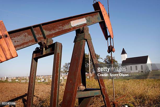 Rusting oil well sits at the edge of a corn field near the Asbury Methodist Chruch on October 4, 2008 near New Haven, Illinois. Crude oil production...