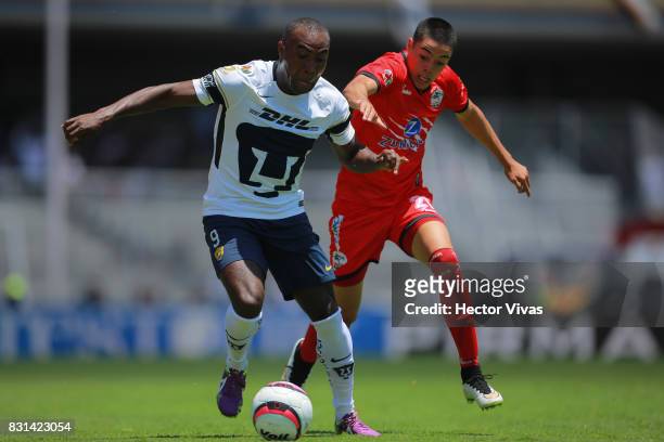 Joffre Guerron of Pumas struggles for the ball with Eduardo Tercero of Lobos BUAP during the fourth round match between Pumas UNAM and Lobos BUAP as...