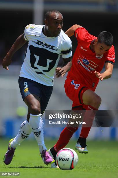 Joffre Guerron of Pumas struggles for the ball with Eduardo Tercero of Lobos BUAP during the fourth round match between Pumas UNAM and Lobos BUAP as...