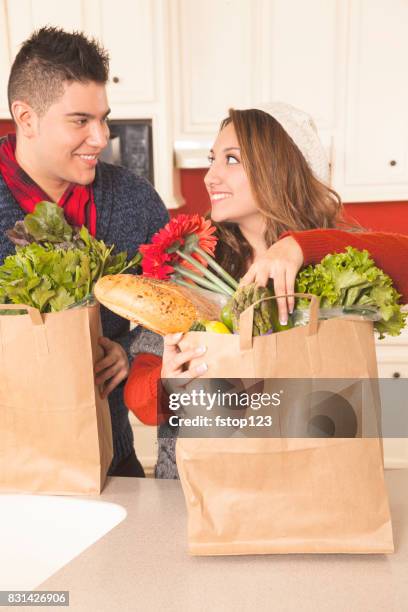 latijnse afdaling paar uitpakken boodschappen in huis keuken. - latin american and hispanic shopping bags stockfoto's en -beelden