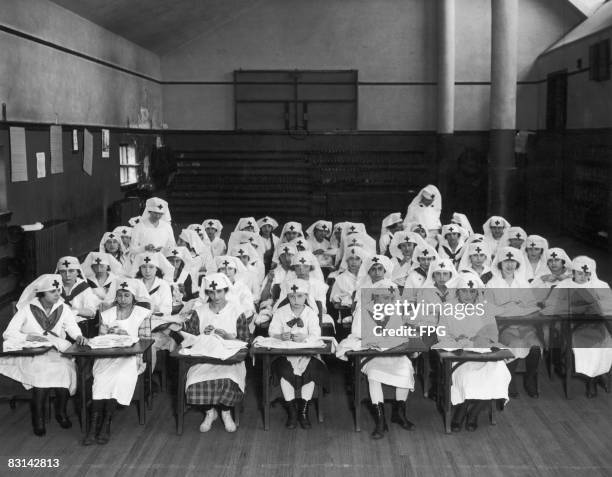 Girls at a school on the East Side of New York, sewing clothing for children in the war zones of France and Belgium, under the auspices of the...