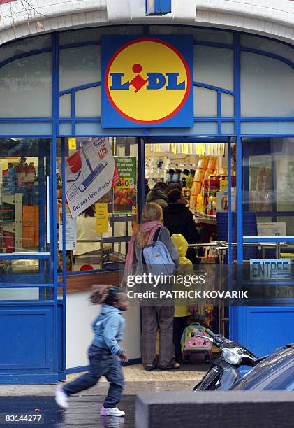 Des personnes passent devant un magasin de hard discount Lidl à Clichy sur Seine, le 03 octobre 2008. Le secrétaire général de FO Jean-Claude Mailly...