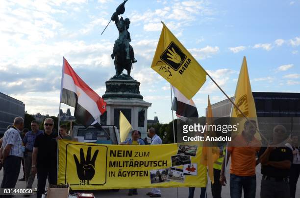 People hold placards during a protest marking the fourth anniversary of Rabaa El Adaweya massacre in Vienna, Austria on August 14, 2017. Rabaa El...