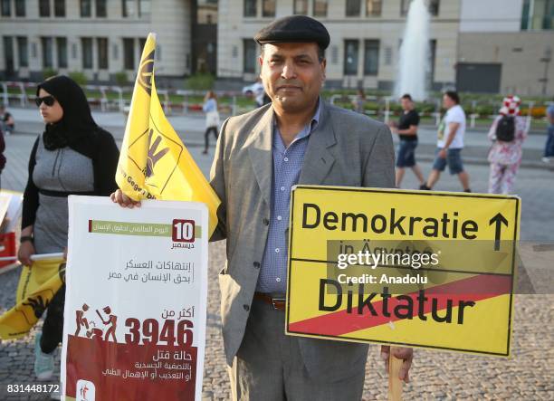 An Egyptian, who lives in Germany, holds a placard during a protest, organised by German-Egyptian Union for Democracy, marking the fourth anniversary...