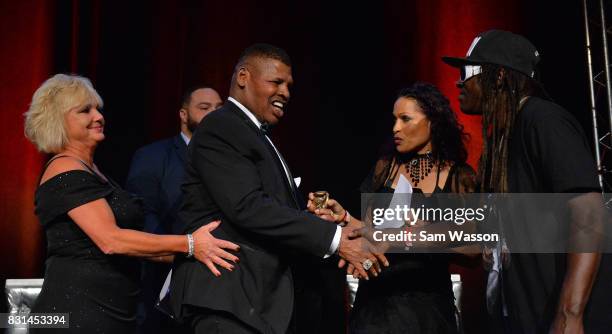 Former boxer Leon Spinks is greeted by rapper Flavor Flav as Spinks is inducted into the Nevdada Boxing Hall of Fame at the the fifth annual...