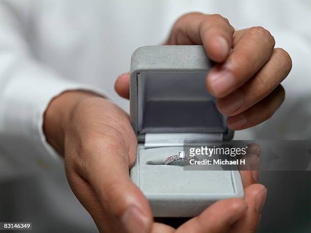 hand that presents ring - engagement ring box - fotografias e filmes do acervo