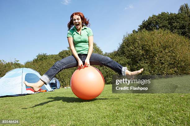 portrait of woman bouncing on rubber ball - hoppity horse stock pictures, royalty-free photos & images