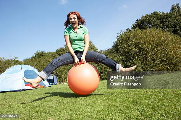 portrait of woman bouncing on rubber ball - bounce bildbanksfoton och bilder