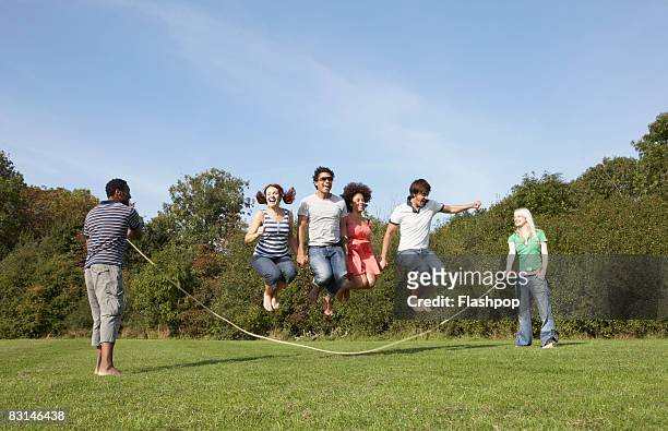group portrait of friends skipping - jump rope stockfoto's en -beelden