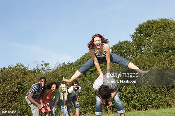 portrait of woman jumping over the top of man - friends prank stock pictures, royalty-free photos & images