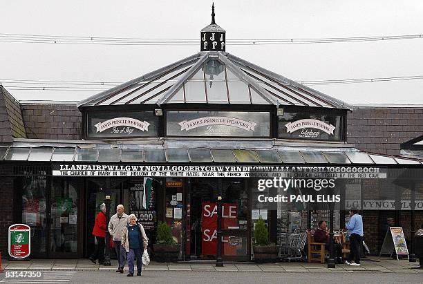 Tourists leave the souvenir shop at Llanfairpwllgwyngyllgogerychwyrndrobwllllantysiliogogogoch in Anglesey, Wales, on October 6, 2008. The name of...