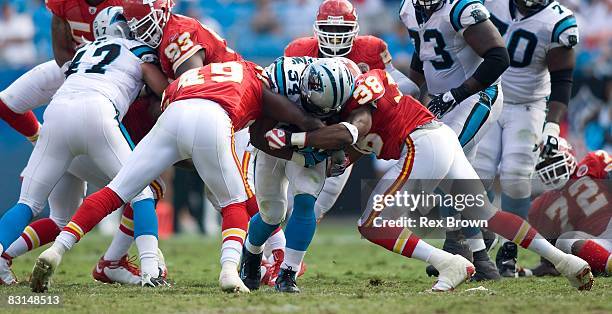 DeAngelo Williams of the Carolina Panthers is tackled by Bernard Pollard and DaJuan Morgan of the Kansas City Chiefs at Bank of America Stadium on...