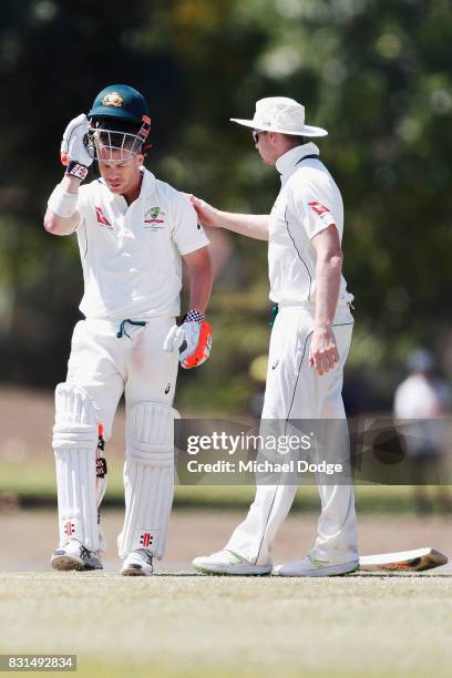 David Warner is attended to by Steve Smith after being hit by a Josh Hazelwood bouncer during day two of the Australian Test cricket inter-squad...