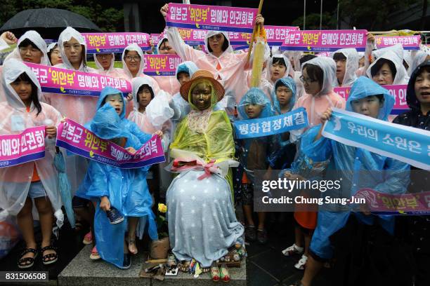 South Korea activists pose with comfort woman statue during a 72nd Liberation Day rally in front of Japanese embassy on August 15, 2017 in Seoul,...
