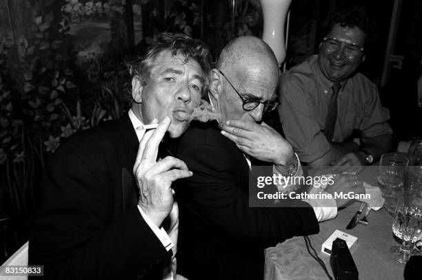 British Actor Sir Ian McKellen, left, blows cigarette smoke next to American playwright and gay rights activist Larry Kramer at a party at Tavern on...