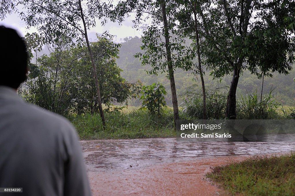 Man watching heavy rain on country road