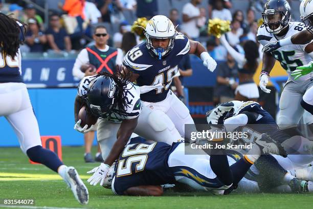 Eddie Lacy of the Seattle Seahawks is tackled by James Onwualu of the Los Angeles Chargers and Korey Toomer of the Los Angeles Chargers in the second...