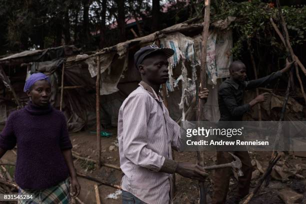 Men dismantle a roadside stand that was burnt the during unrest the day prior in the Mathare North neighborhood on August 14, 2017 in Nairobi, Kenya....